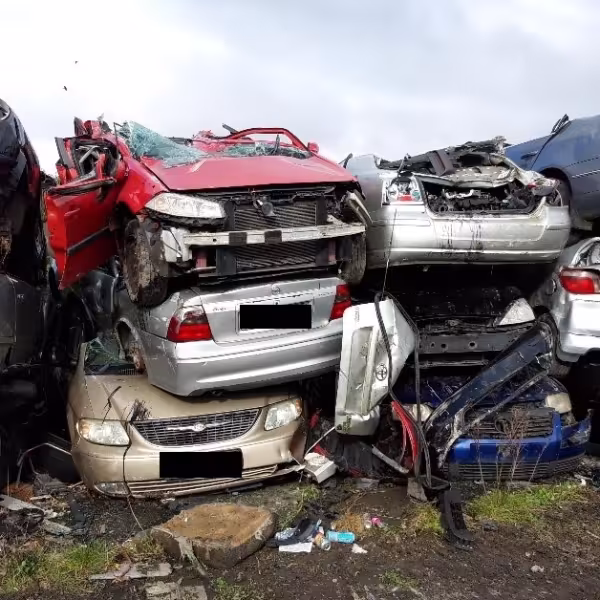 A pile of partially crushed vehicles stacked upon one another