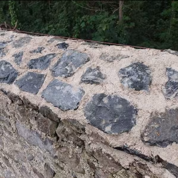 Work in progress on reinstatement of the wall at Cobbe's Lane includes capping with new flaunched stonework and lime bedding to match original.