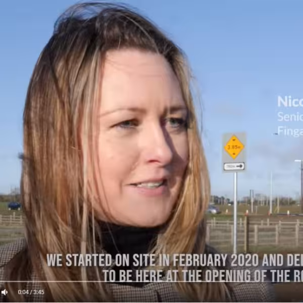 Blonde woman speaking to camera at roadside