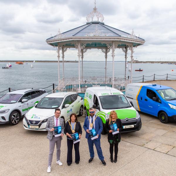 4 Mayors stand at cars holding document