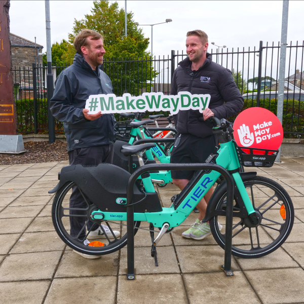 Two men with bike at bike stand