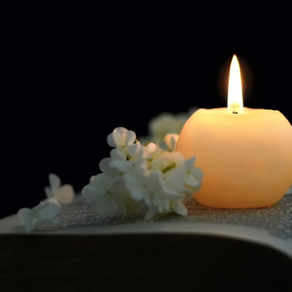 Candle and flowers on book