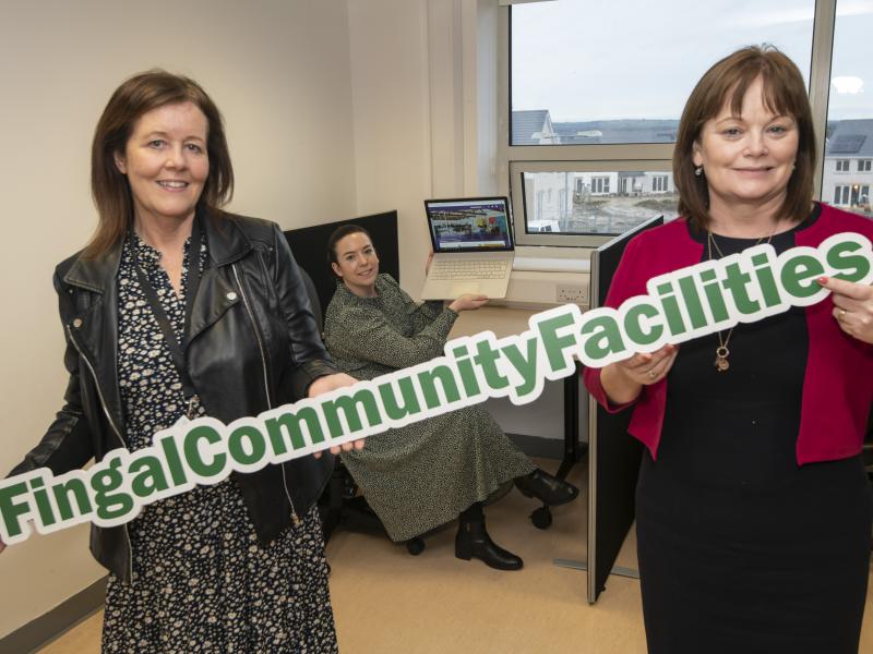Two women in office holding sign that says Fingal Community Facilities