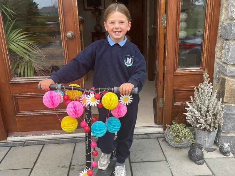 girl with decorated scooter in school uniform