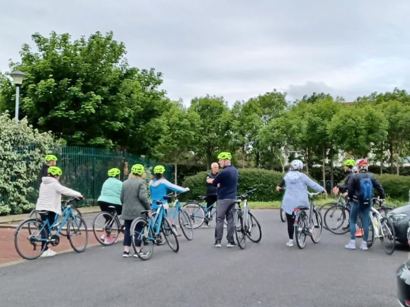 Group of adults standing with bikes backs faced to camera