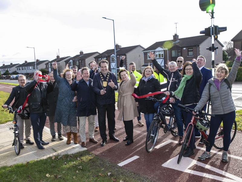 group cutting ribbon and cheering standing at cycle lane