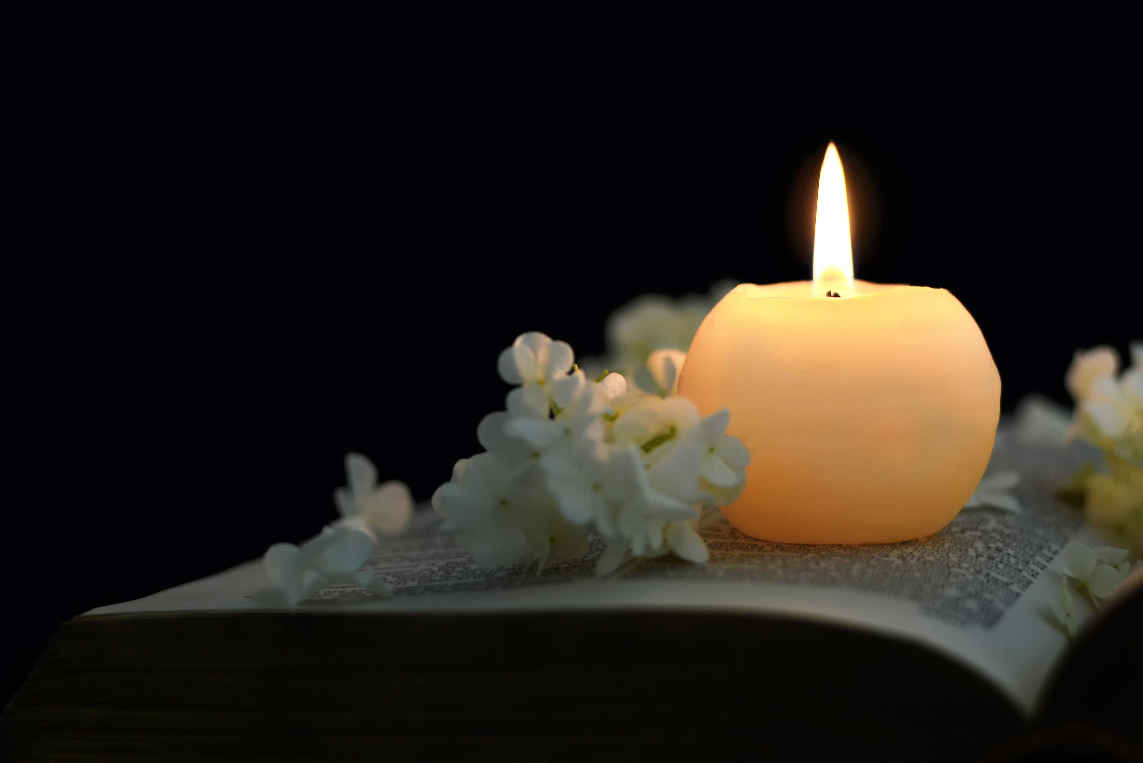 Candle and flowers on book