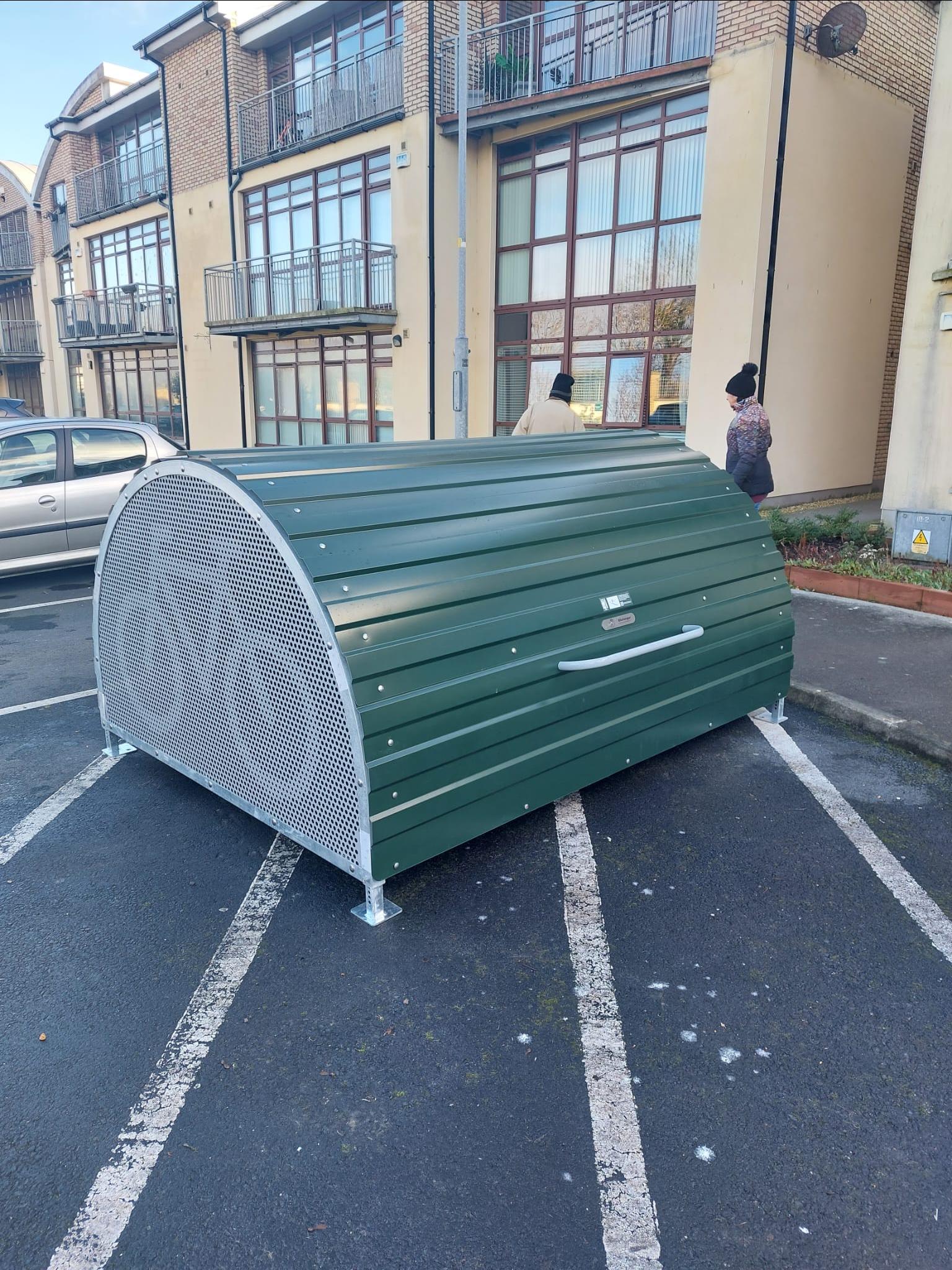 Bike storage bunker grey metal half cylinder with green metal door