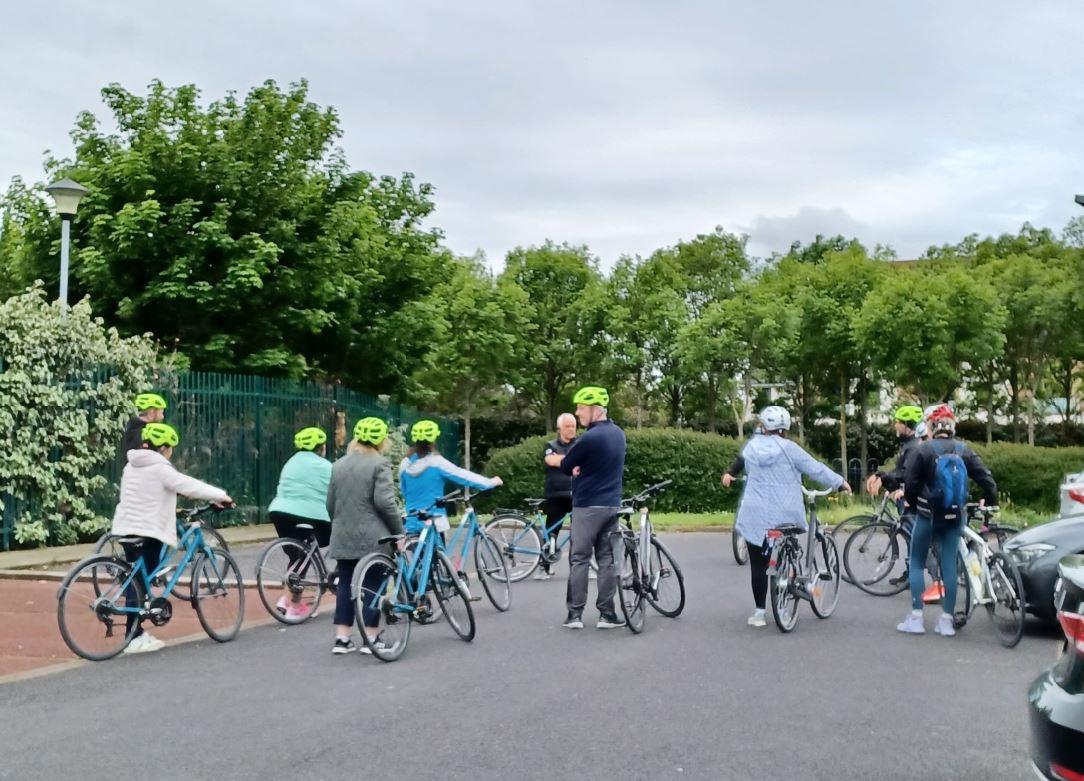 Group of adults standing with bikes backs faced to camera