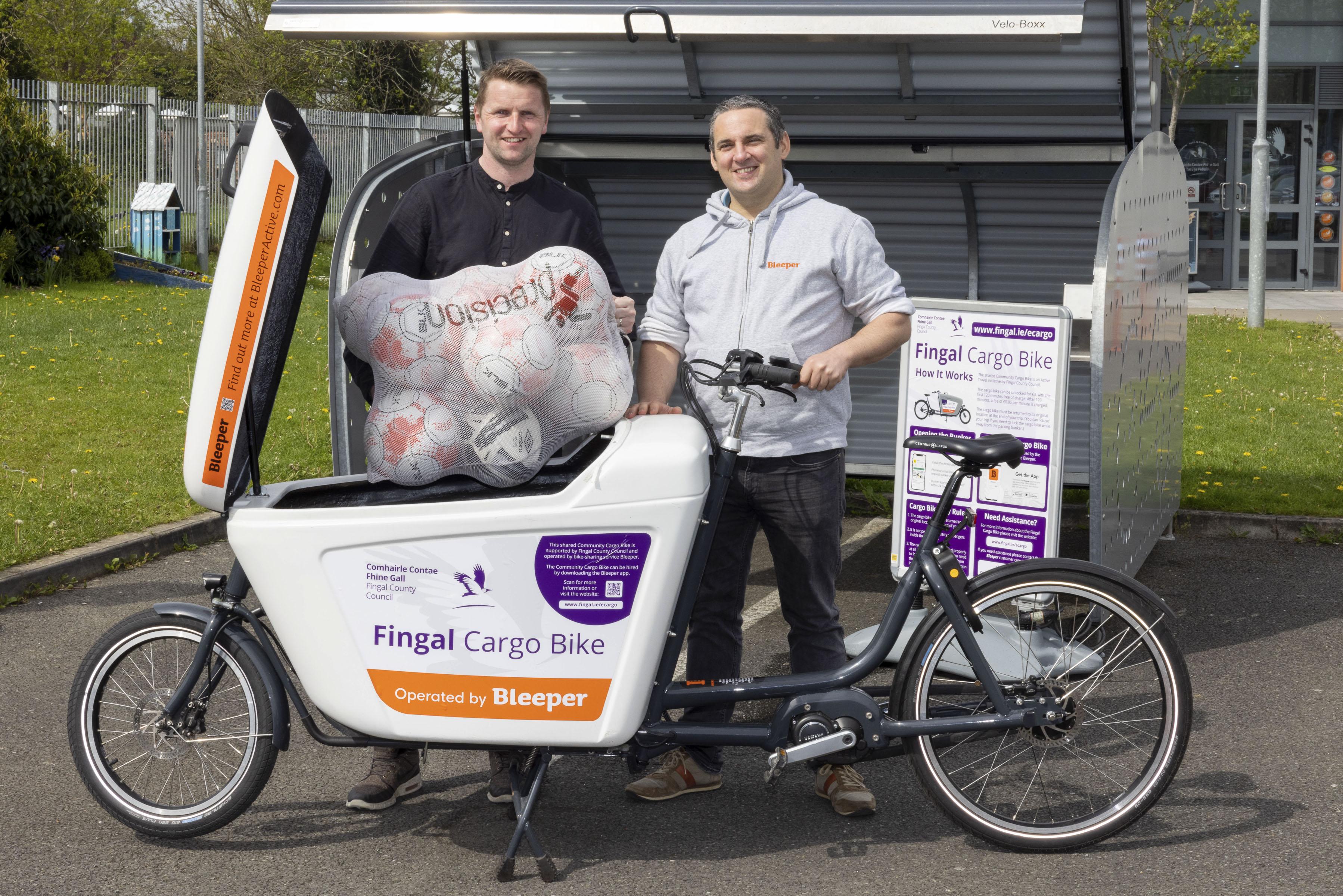 Two men putting sports equipment into ecargo bike