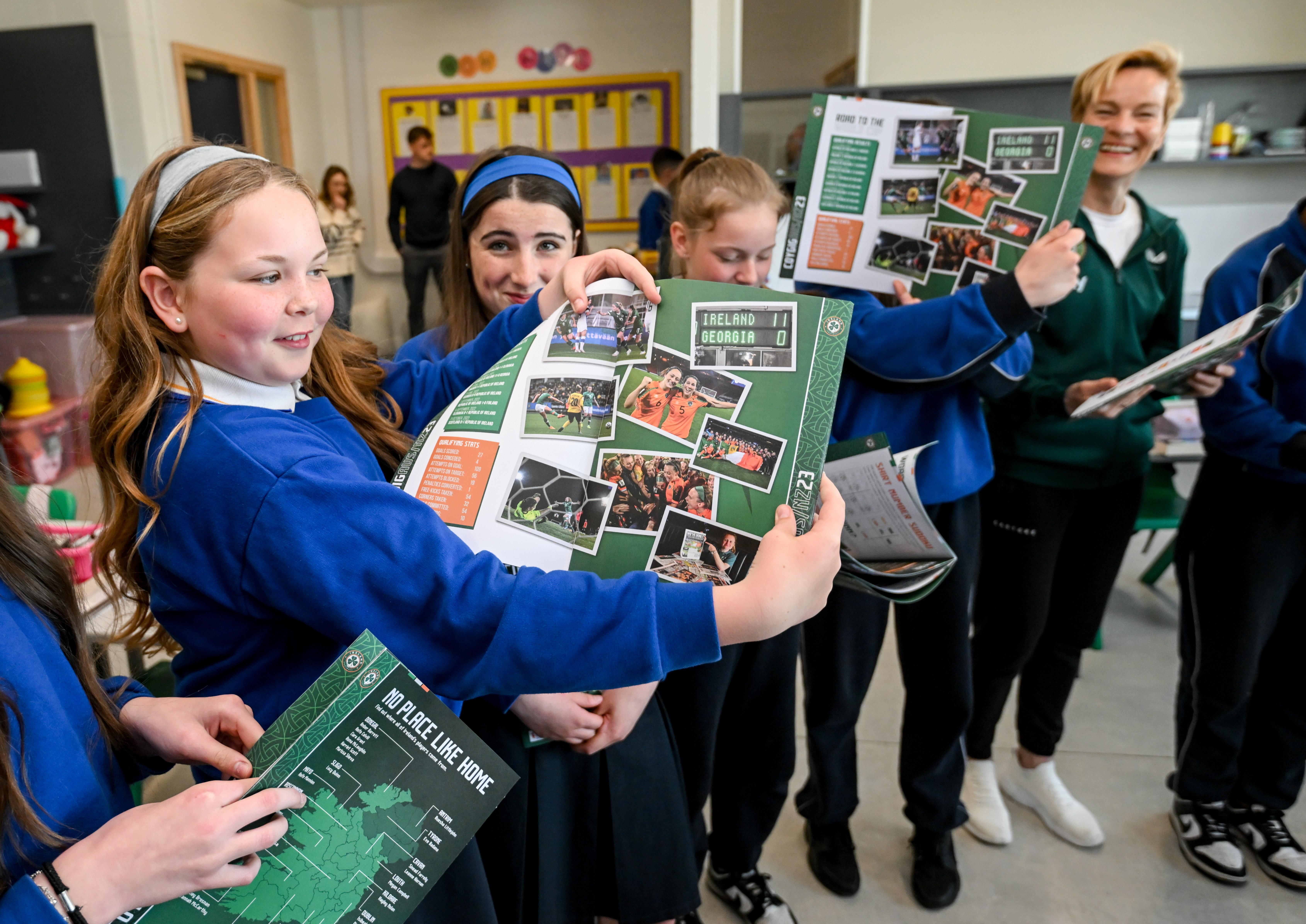Girl in school uniform holds activity book open