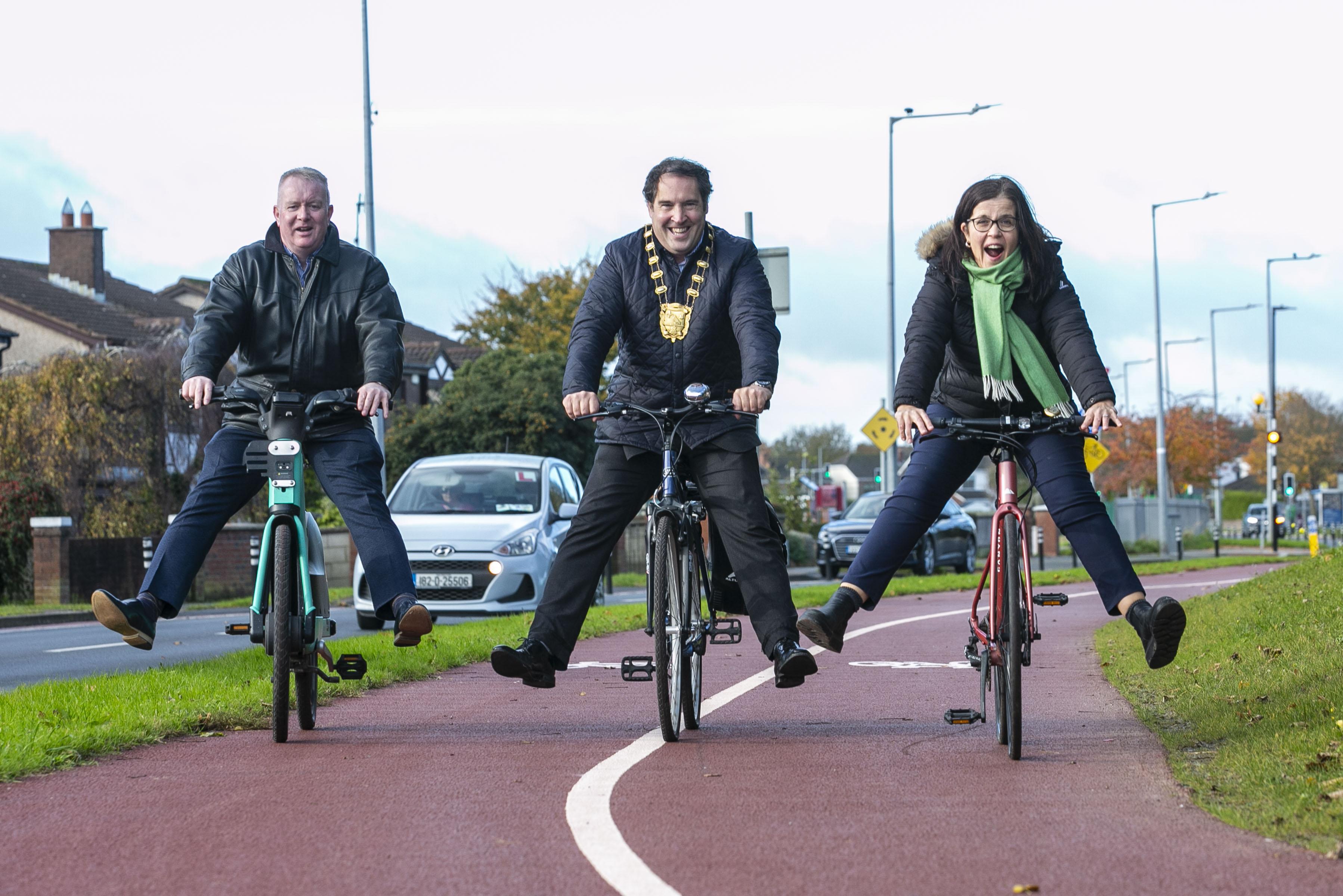 three people cycling with happy faces