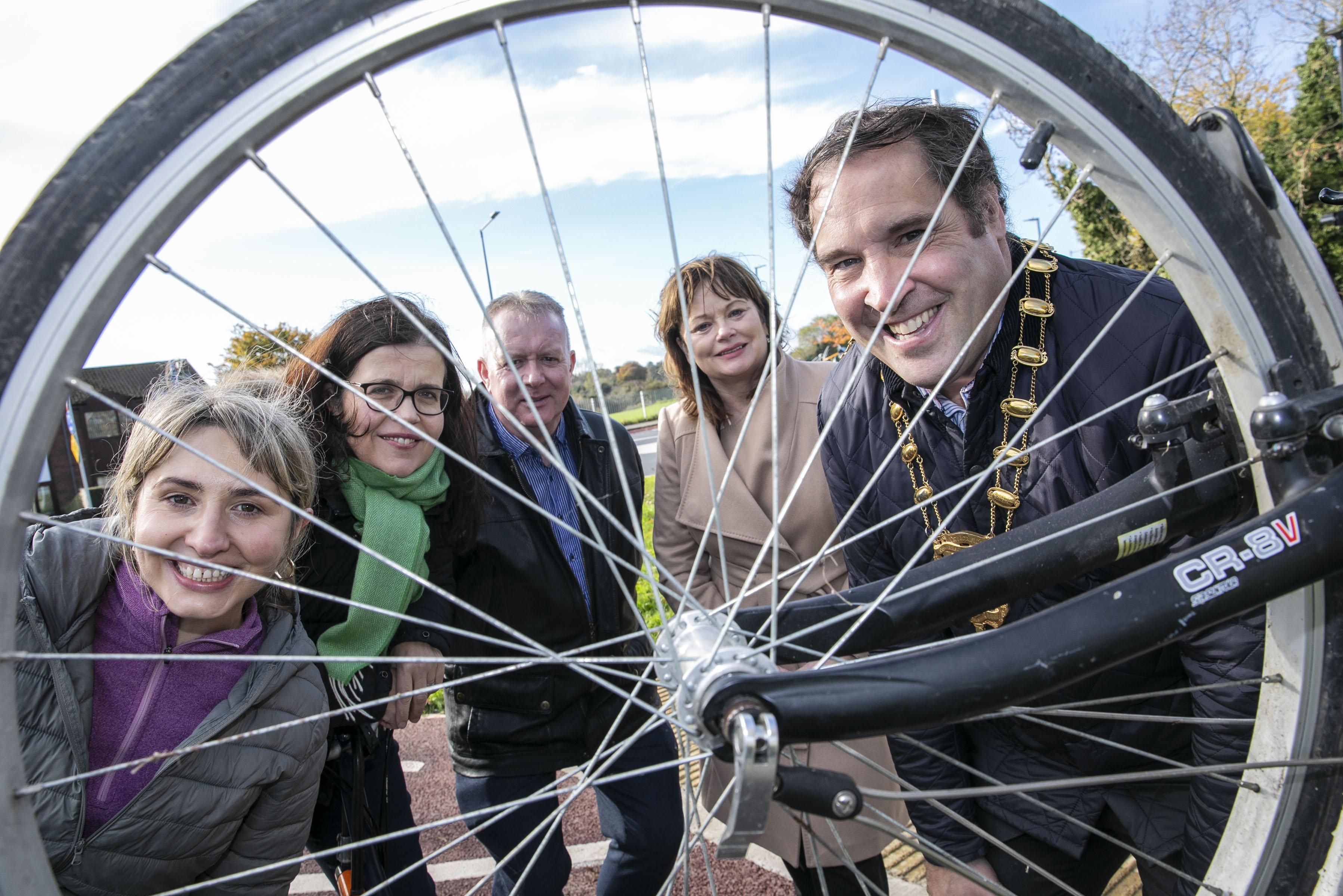 mayor and others look through spokes of bicycle